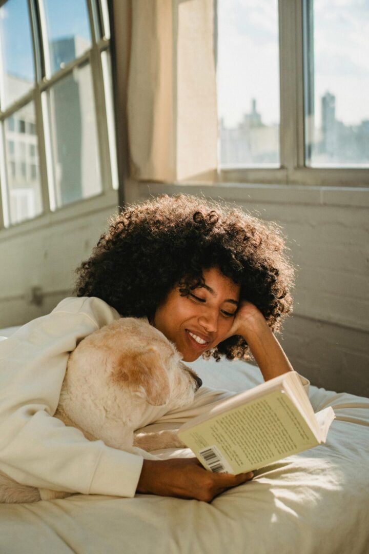 A woman laying in bed reading a book.