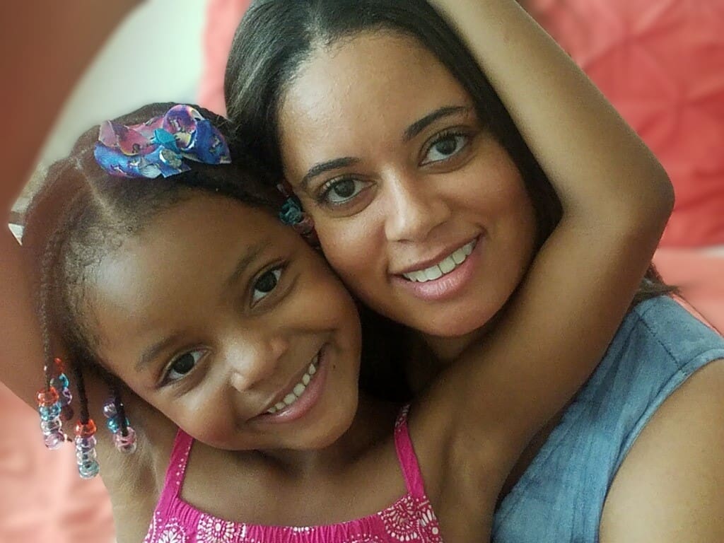 A woman and her daughter posing for the camera.