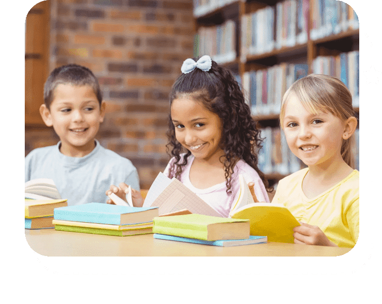 A group of children sitting at a table with books.